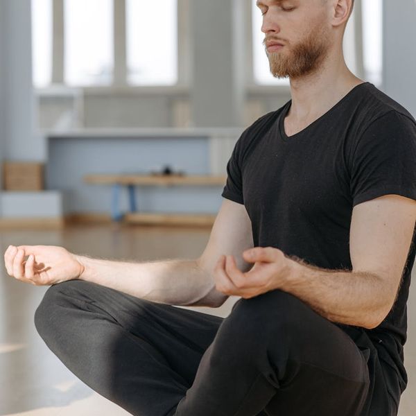 Person meditating peacefully in a calm yoga studio environment.